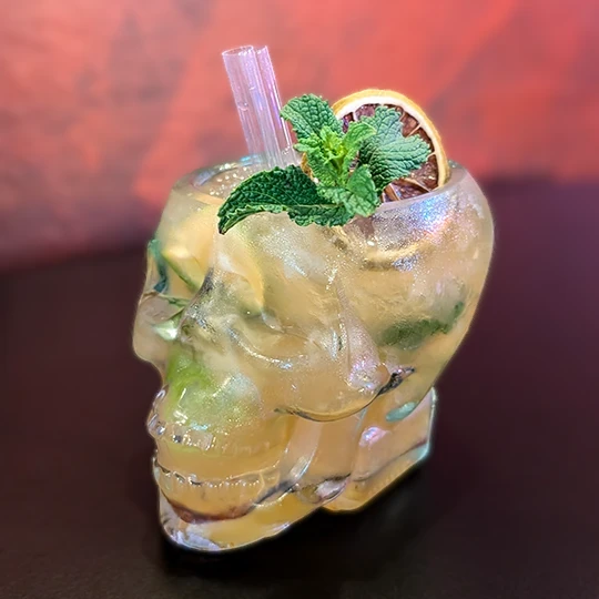 Mojito finished and decorated with mint and dehydrated lemon slice, presented in a skull-shaped glass, showing the creativity in the cocktail bar of Inferno Gastro Bar.