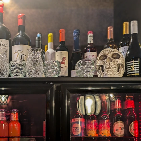 Inferno Gastro Bar with a wide selection of wines and spirits displayed on shelves and refrigerators, creating a cozy and elegant atmosphere for wine and cocktail lovers.